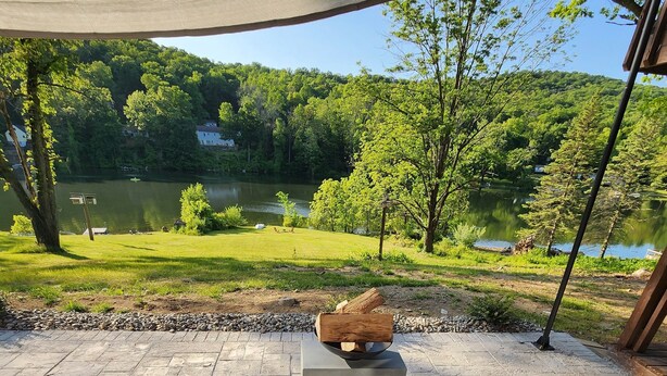 An outdoor seating area with a view of a lake and forest. - Red Cabin Lake House with Amazing Views! (Vernon Township)