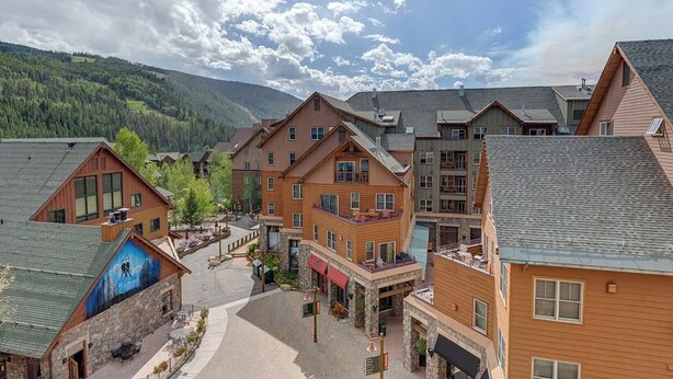 A cluster of wooden buildings with balconies, a central courtyard, and a mountain backdrop. - The Baldwin - Luxury Penthouse in the Heart of Keystone - Ski In/Out• $0 Cleaning Fee (Keystone)