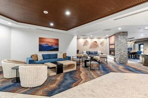 Um interior moderno com um sofá azul, uma lareira e uma área de jantar.