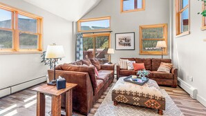 A spacious living room with a high ceiling, large windows, and a view of a mountainous landscape. - The Baldwin - Luxury Penthouse in the Heart of Keystone - Ski In/Out• $0 Cleaning Fee (Keystone)