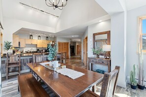 A spacious kitchen with wooden cabinets, a dining area with a large wooden table, and a living area with a large mirror and cactus plants. - The Baldwin - Luxury Penthouse in the Heart of Keystone - Ski In/Out• $0 Cleaning Fee (Keystone)