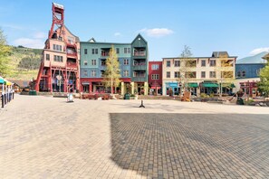 A square plaza with colorful buildings, benches, and a prominent red structure.