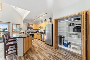 Une cuisine moderne avec des meubles en bois, des appareils en acier inoxydable et un îlot central intégré avec des sièges.