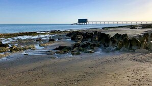 A rocky beach with a pier extending into the sea. - Solent Landing No 16 Beach Retreat (Bembridge)