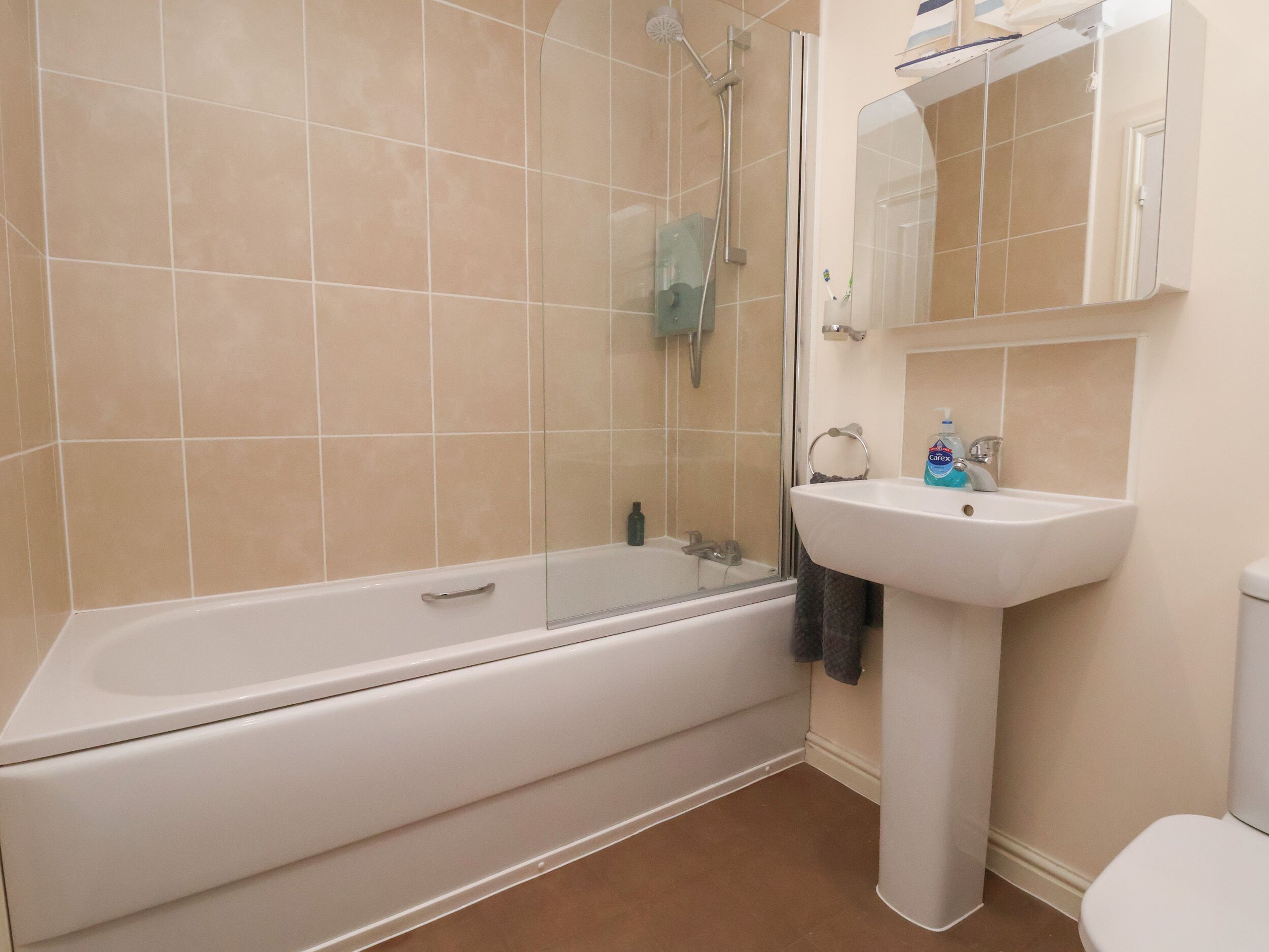 A bathroom with a bathtub, a sink, and a mirror.