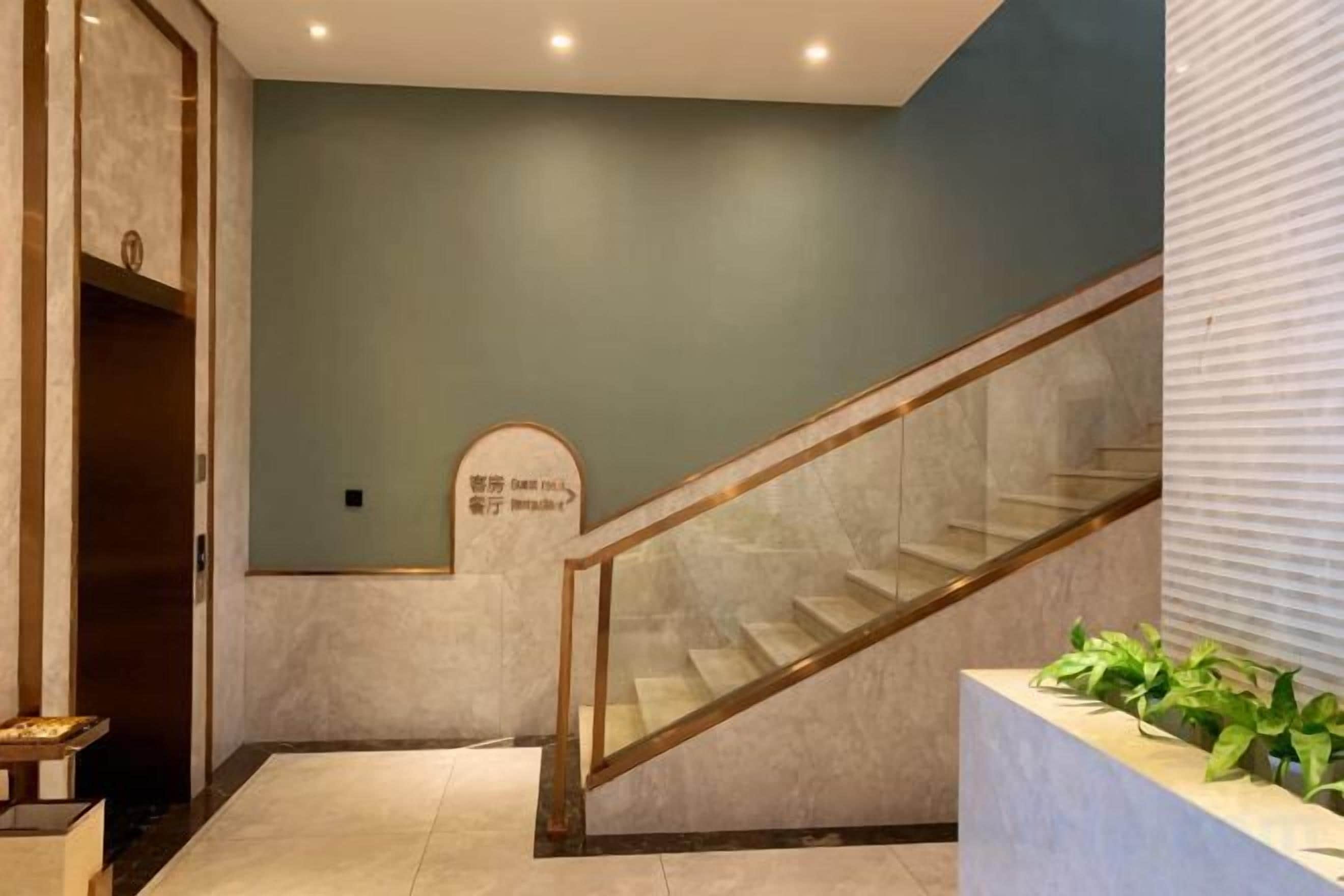 A staircase with glass railings leading to a landing with a sign.