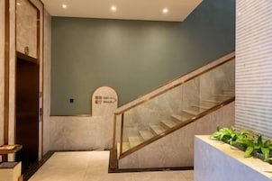 Una escalera con barandillas de vidrio que lleva a una plataforma con un letrero.