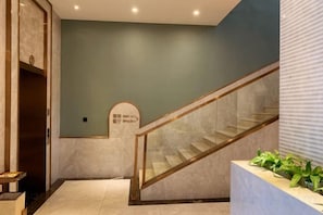 Una escalera con barandillas de vidrio que lleva a una plataforma con un letrero.