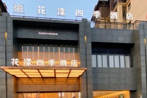 Un hotel con un cartel llamativo que dice 'Flower Seasons' y 'Flower Seasons Hotel Four Seasons'.