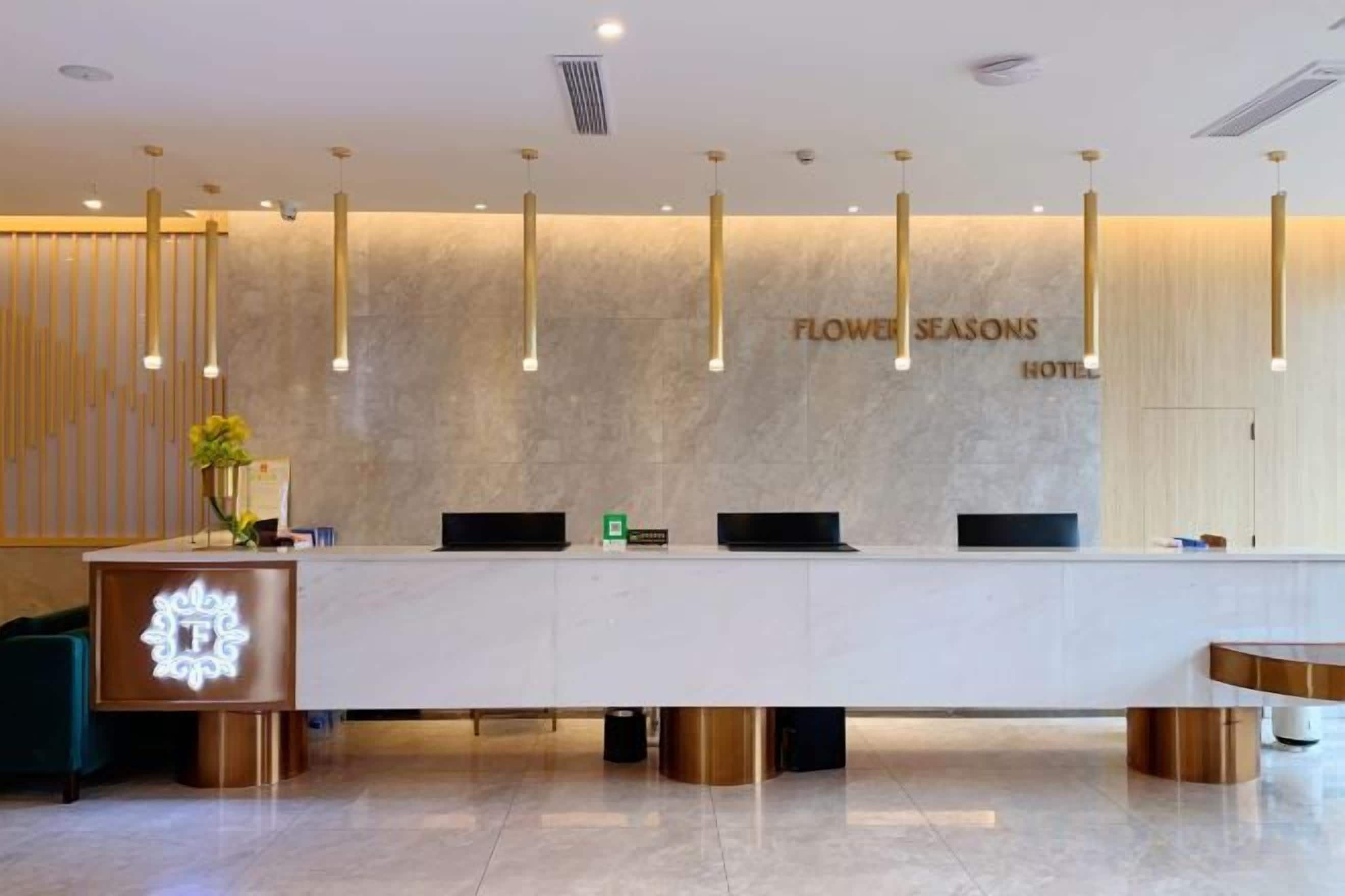 A hotel reception desk with a modern design, featuring a marble countertop, a reception area, and a wall-mounted sign.