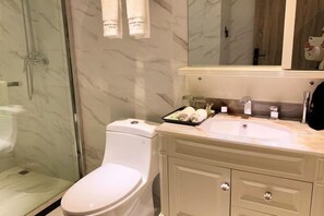 A modern bathroom with a glass-enclosed shower, a white toilet, and a beige vanity with a sink and mirror. - Flower Seasons Hotel (Dafang)