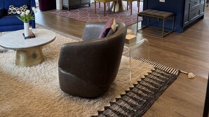 Een moderne woonkamer met een bank, salontafel en een eethoek met een tafel en stoelen.