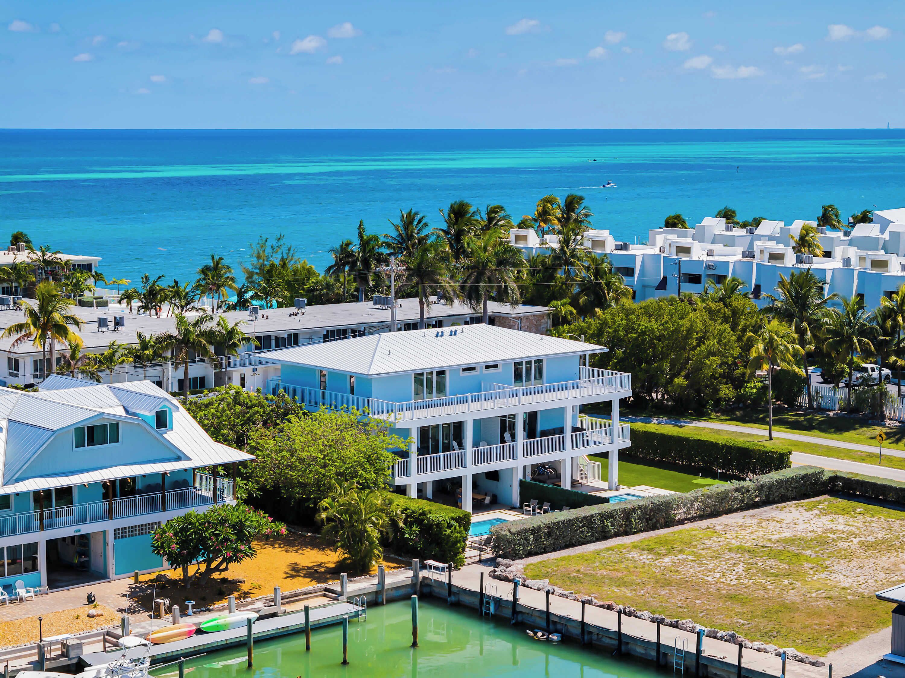A resort with multiple buildings, a pool, and a view of the ocean.
