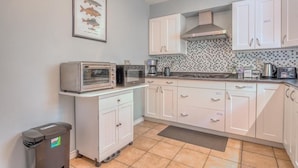 A compact kitchen with white cabinets, a microwave, a toaster, and a coffee maker.