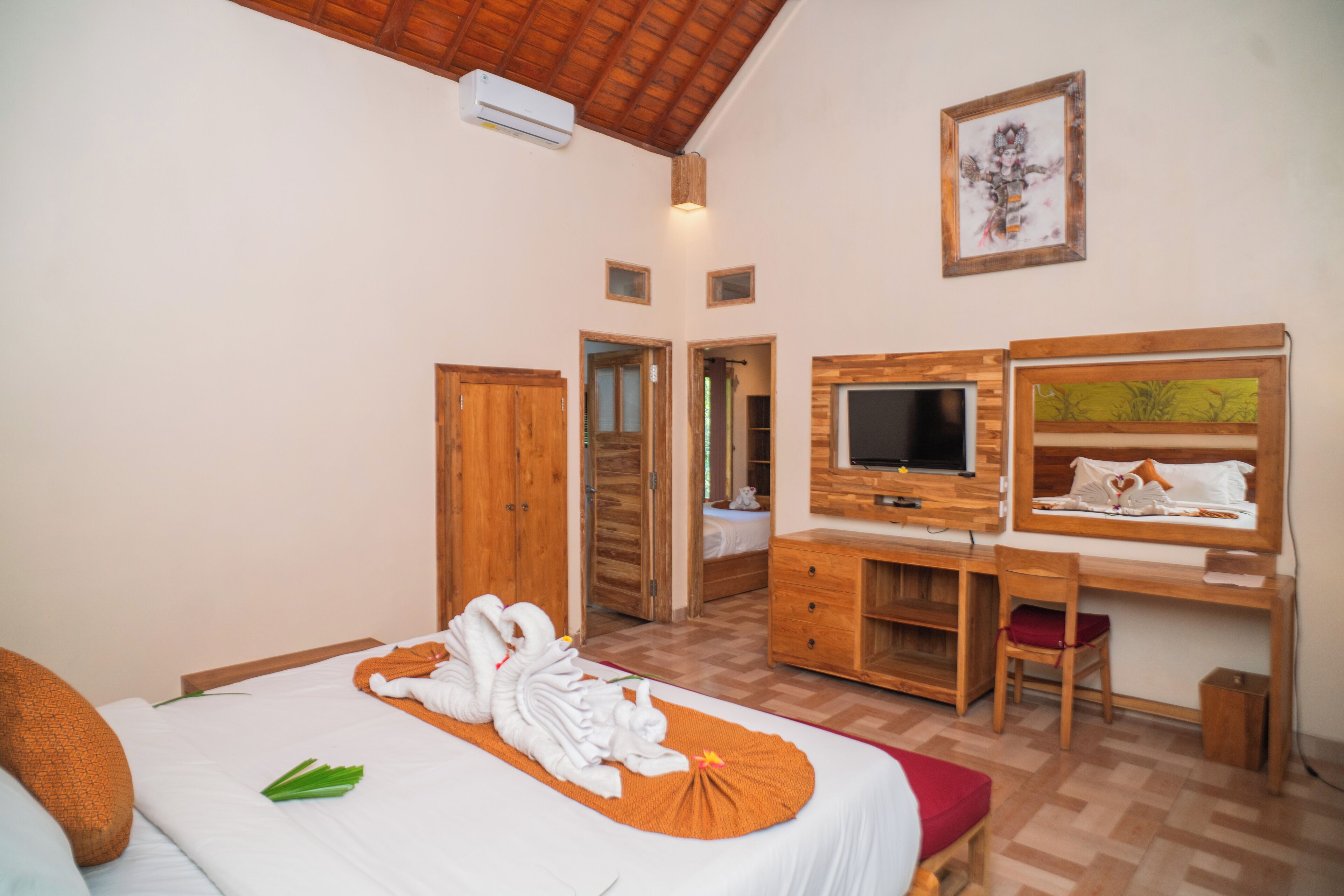 A hotel room with a bed, a desk, a chair, a television, and a wardrobe.