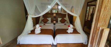 A room with two beds, each with a wooden headboard and white bedding.