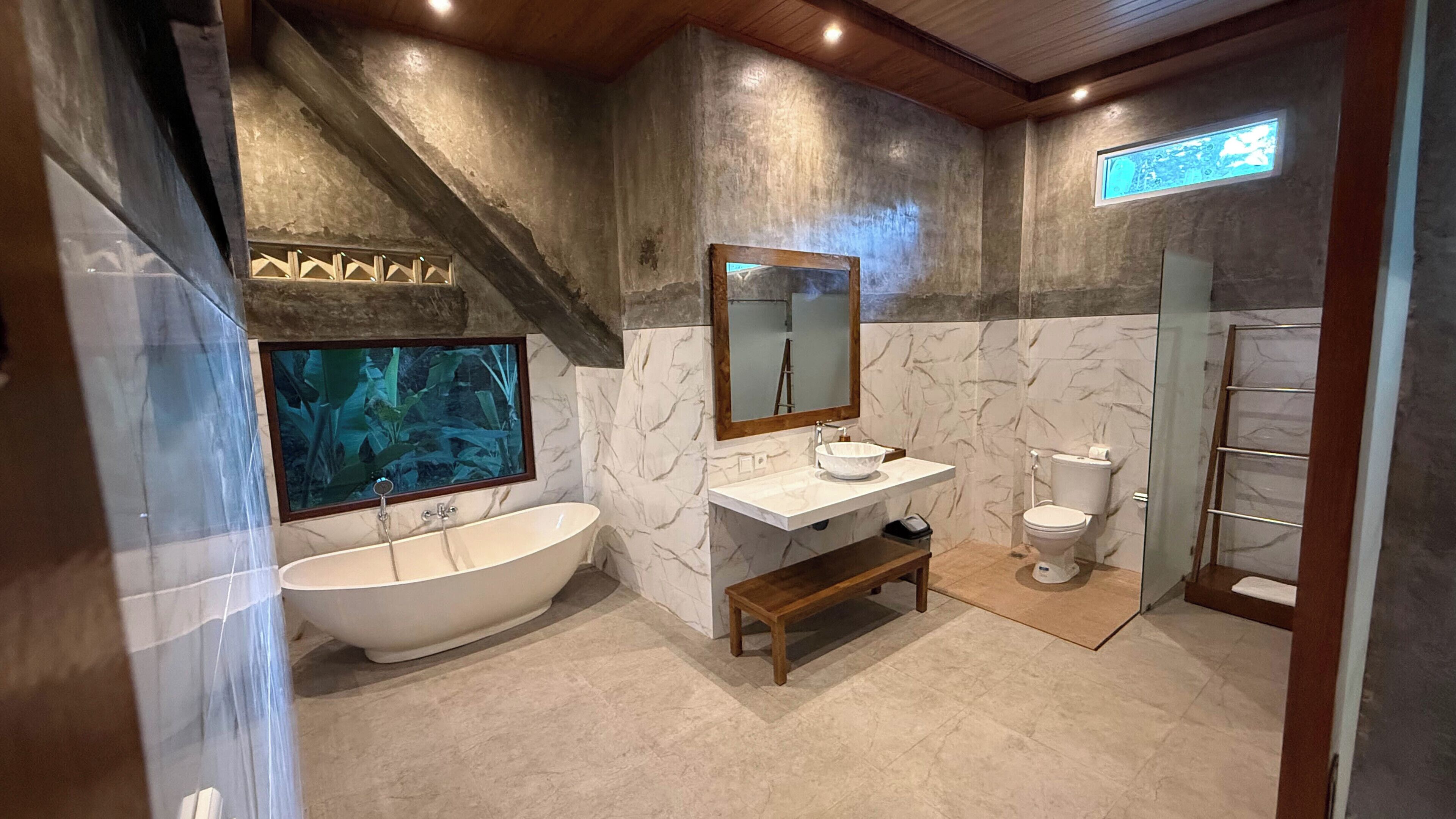 A bathroom with a bathtub, a sink, a toilet, and a shower area.