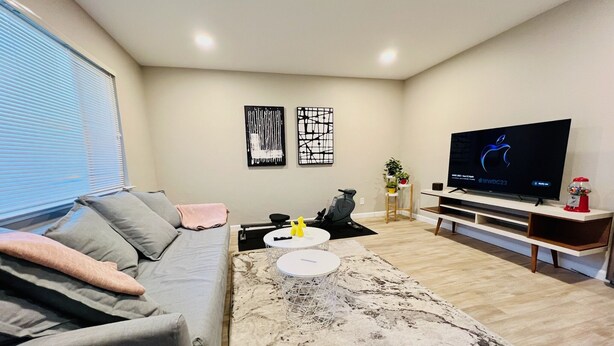 Una sala de estar moderna con un sofá gris, una mesa de centro, un televisor y una alfombra decorativa.