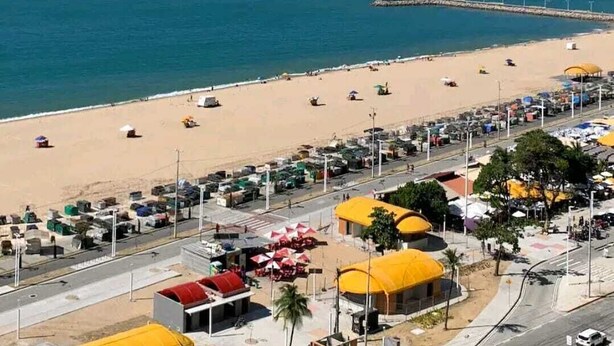 A beach with a parking area and beach umbrellas. - Atlântico Vista Mar Deluxe (Fortaleza)
