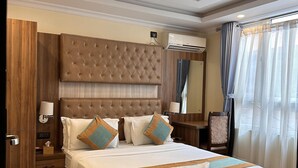 Habitación de hotel con una cama grande, cabecero de madera e iluminación empotrada en el techo.