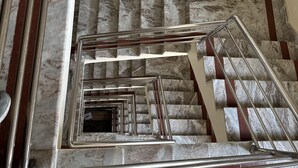 Una escalera de mármol con barandales de metal y pasamanos.