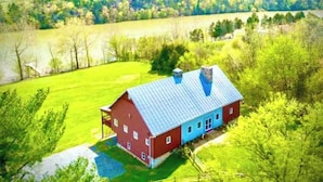 A red barn with a blue roof in a rural setting.