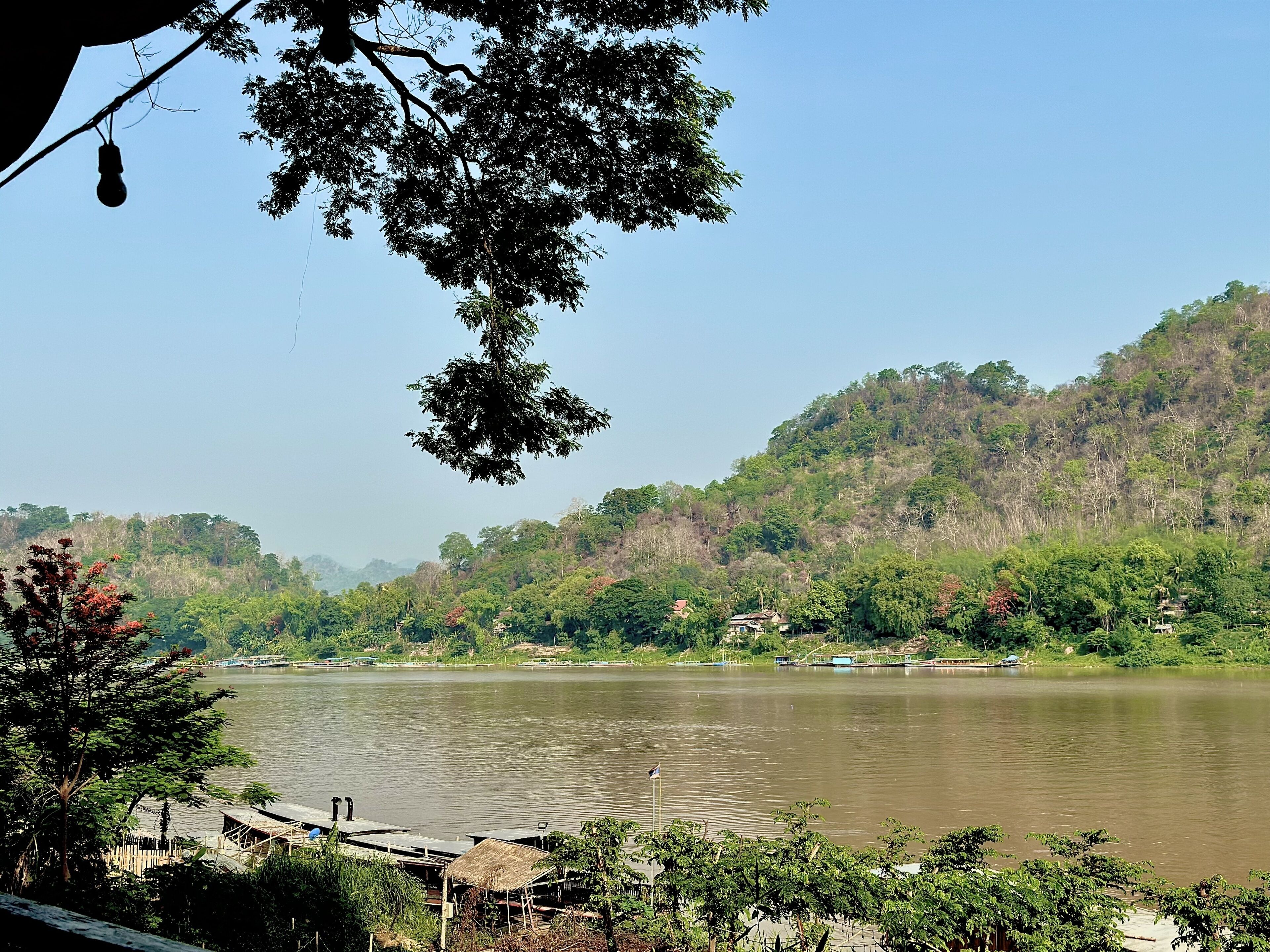 Un río con barcos, rodeado de exuberante vegetación y colinas.
