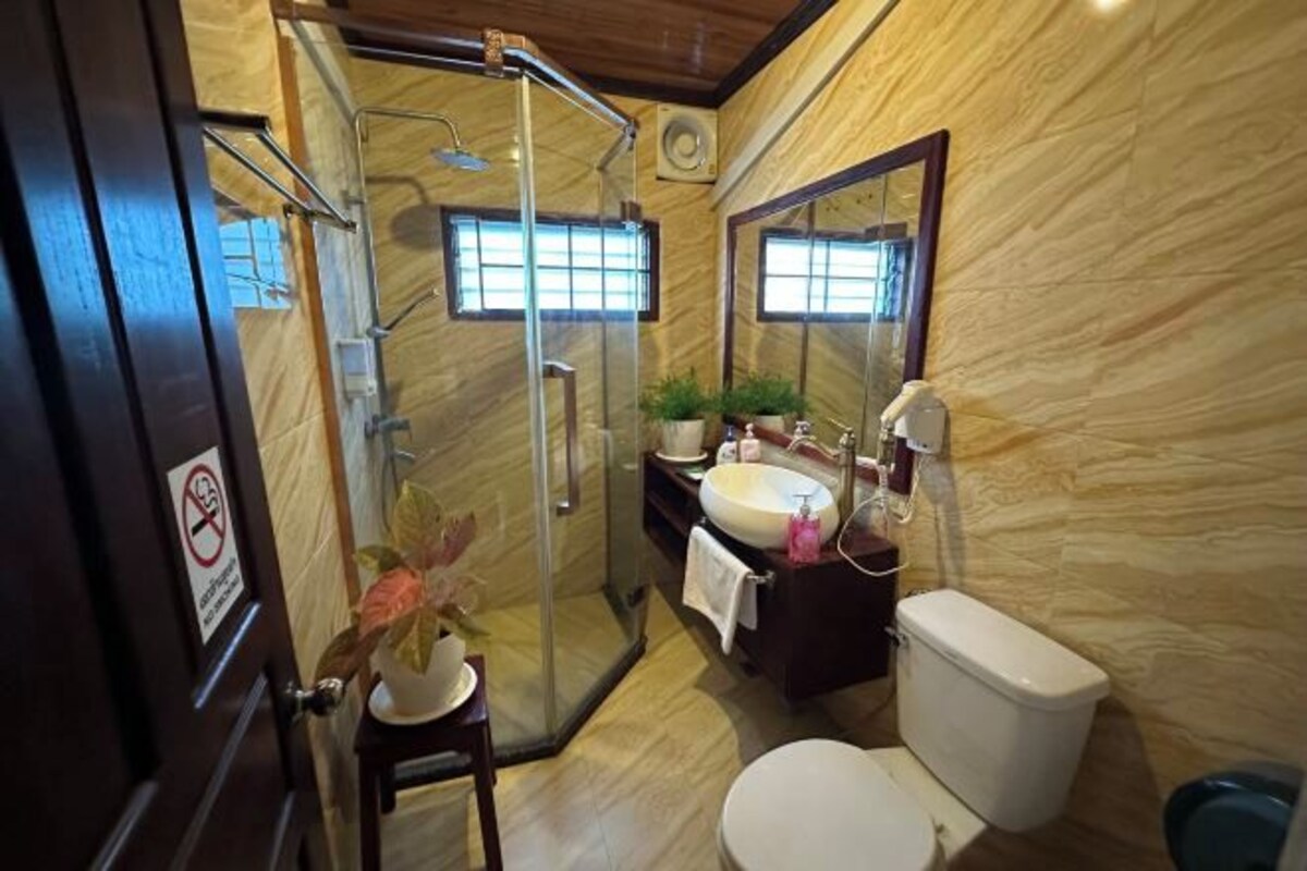 Une salle de bain avec une douche à parois de verre, un lavabo avec un miroir et des toilettes.