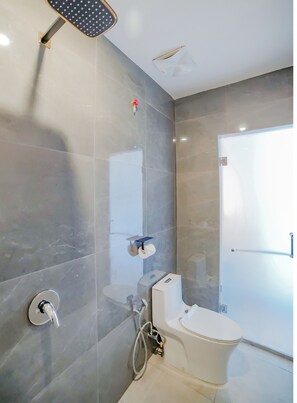 A modern bathroom with a shower, toilet, and a toilet paper holder. - Capital O 90447 Kardopa Hotel Megapark (Medan)
