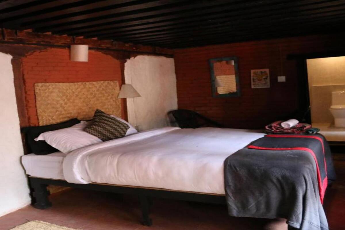 A single bed with a headboard, a bedside table with a lamp, and a wall-mounted picture.