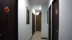 A corridor with doors marked with numbers, leading to individual rooms. - Capital O 3952 Hotel C 18 Cibaduyut (Bandung)