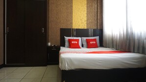 A hotel room with a bed, a wardrobe, and a nightstand. - Capital O 3952 Hotel C 18 Cibaduyut (Bandung)