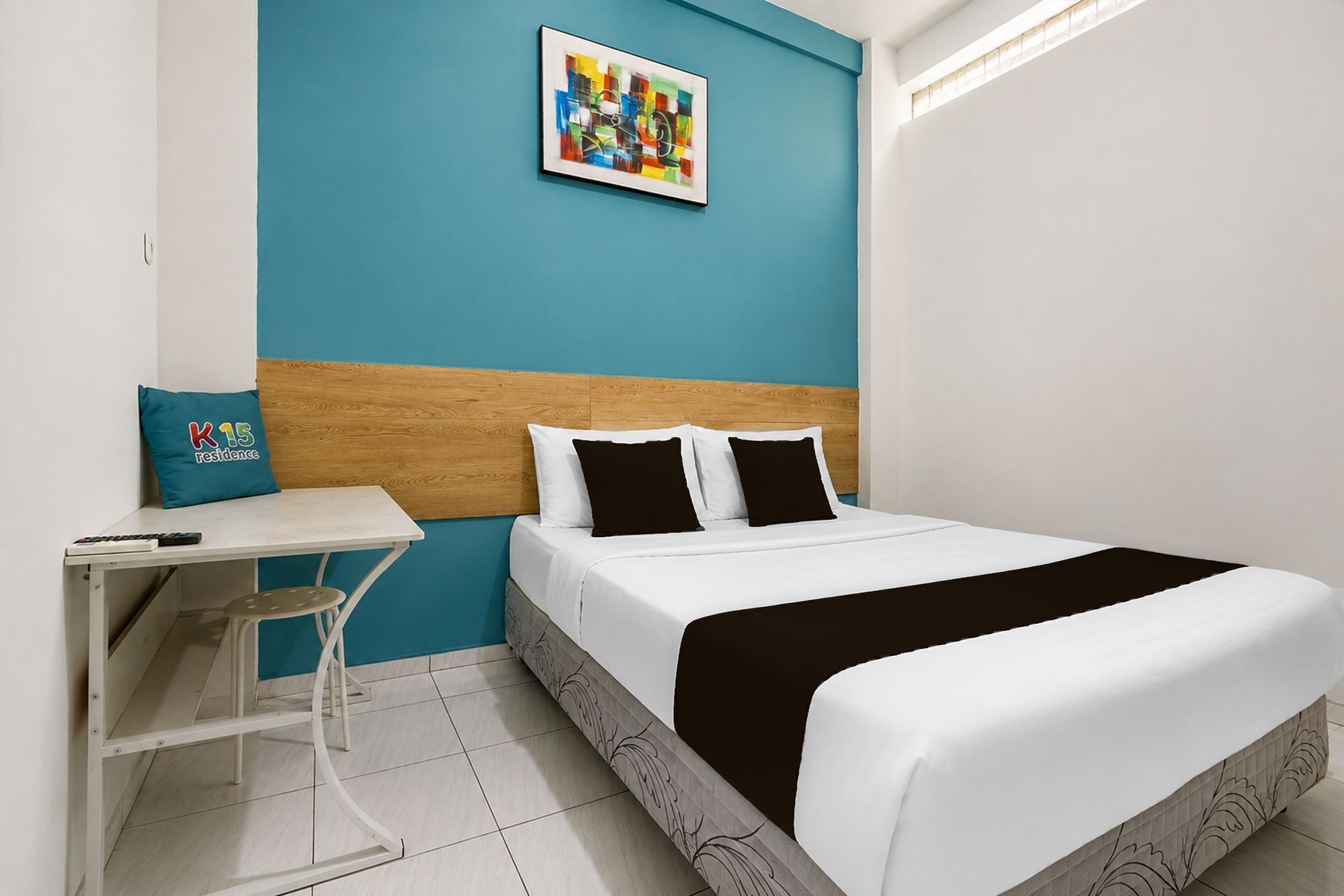 A hotel room with a bed, a desk, and a chair.