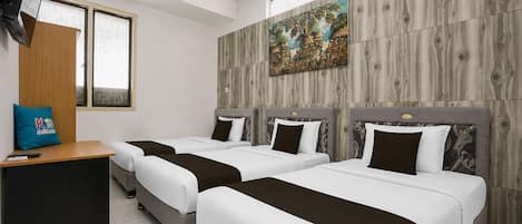 A hotel room with two beds, a desk, a TV, and a painting on the wall.