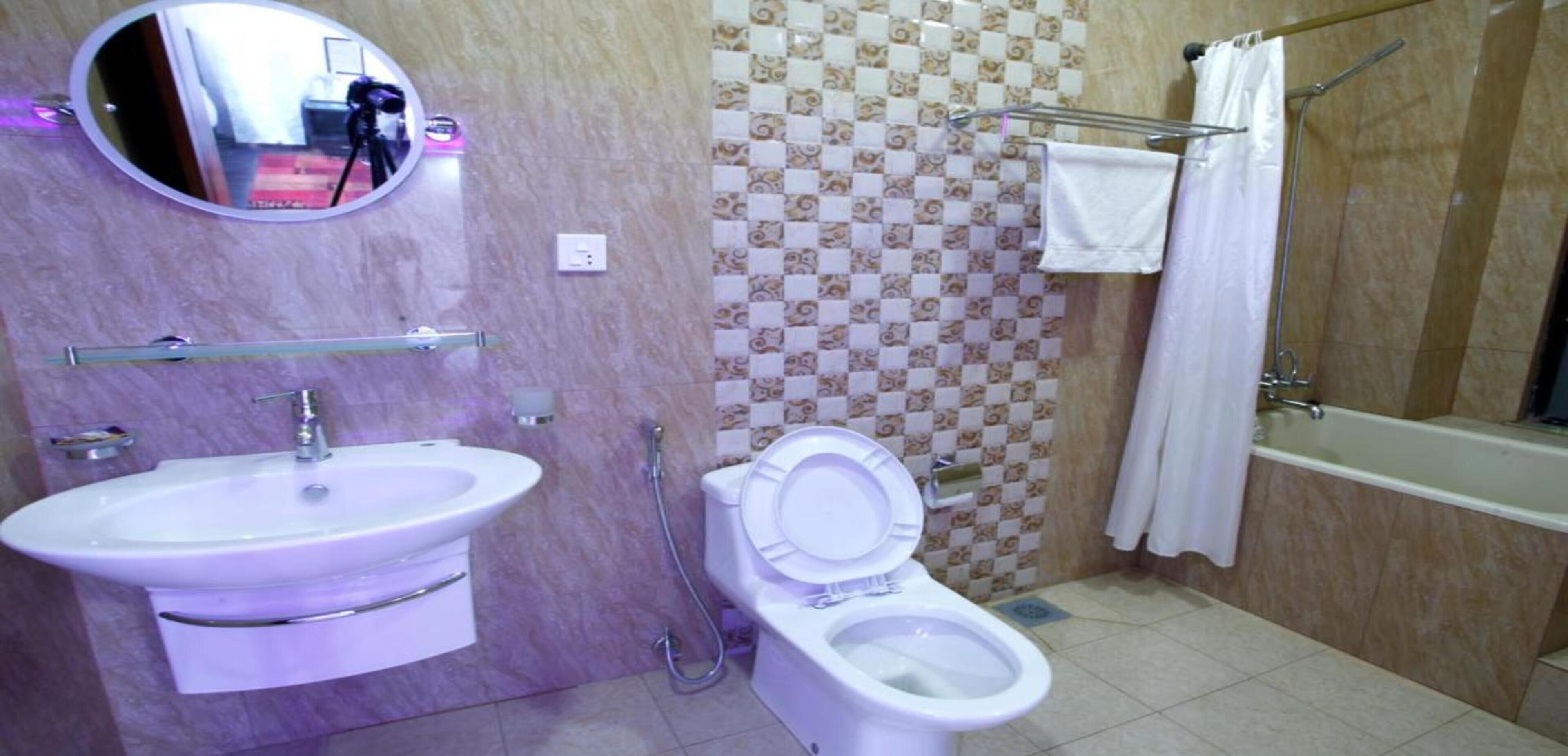 Un baño con lavamanos, inodoro y ducha.