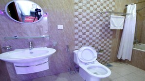 Un baño con lavamanos, inodoro y ducha.