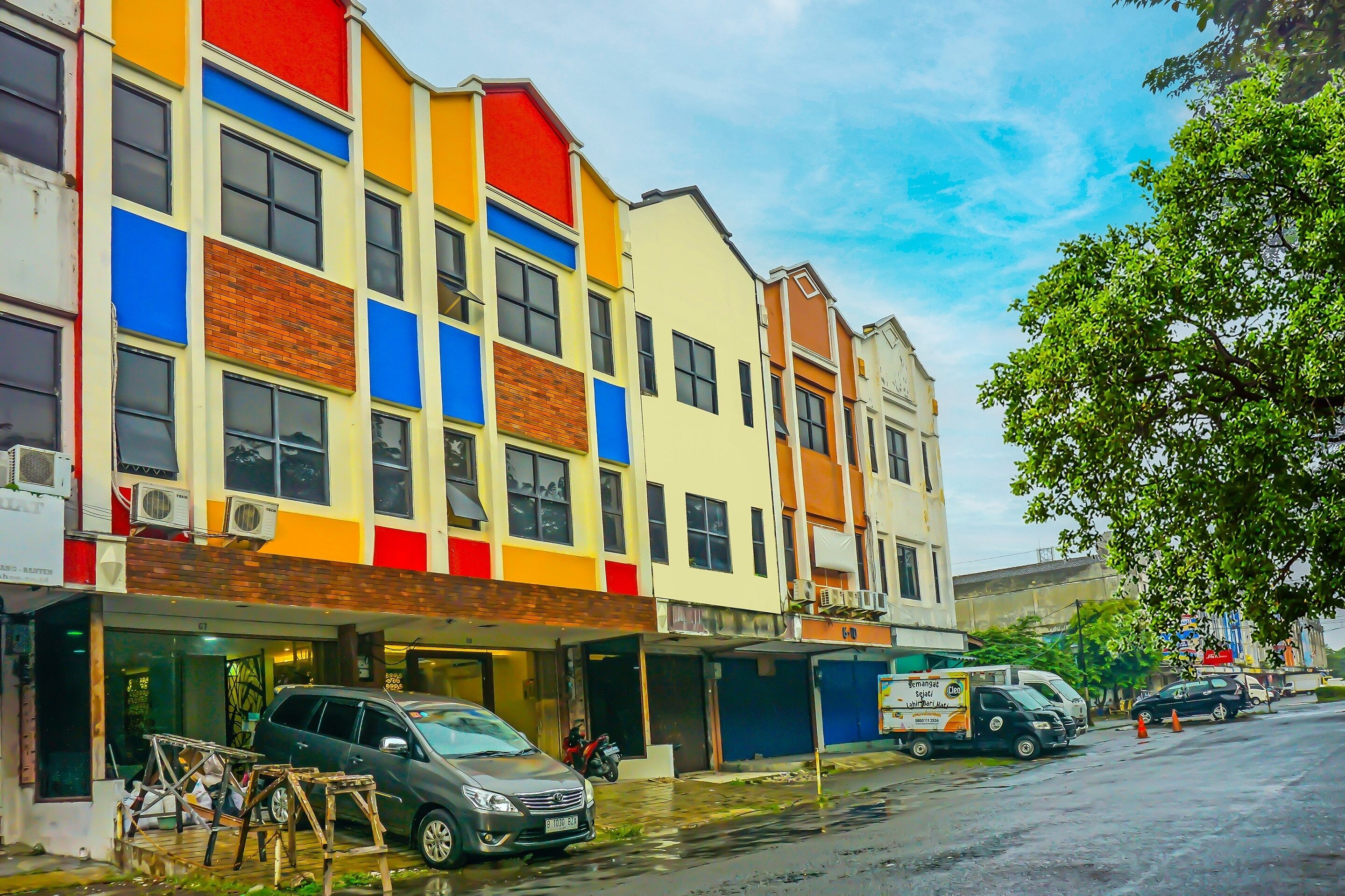 Un immeuble à plusieurs étages, doté d’une façade colorée, qui combine des éléments en brique et des parties peintes.