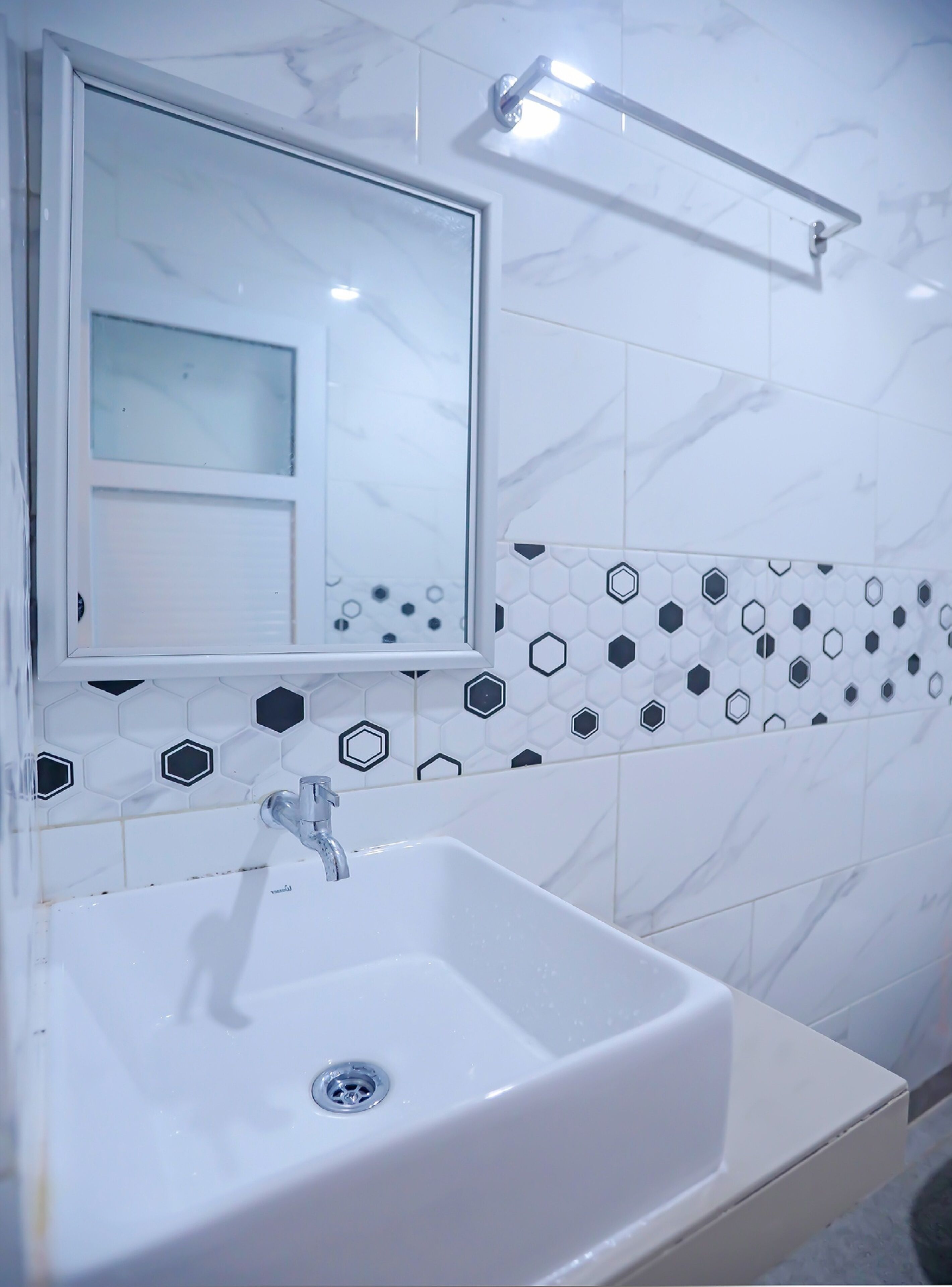 A bathroom with a white sink, a mirror, and a shower area.