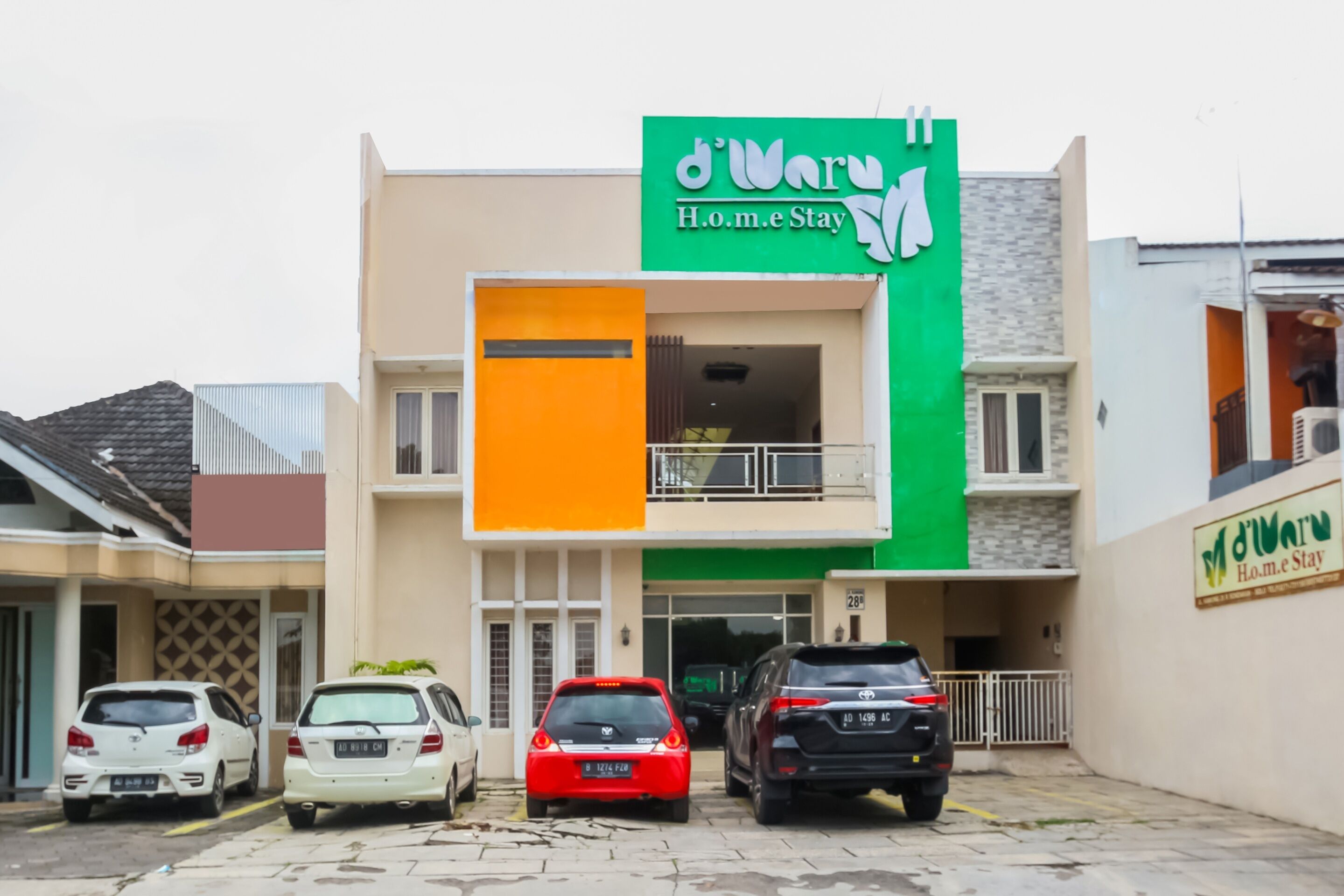 Un edificio con un letrero verde que dice "d'Ware H.o.m.e Stay".