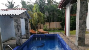 Una piscina con un muro de piedra y un borde de azulejos.
