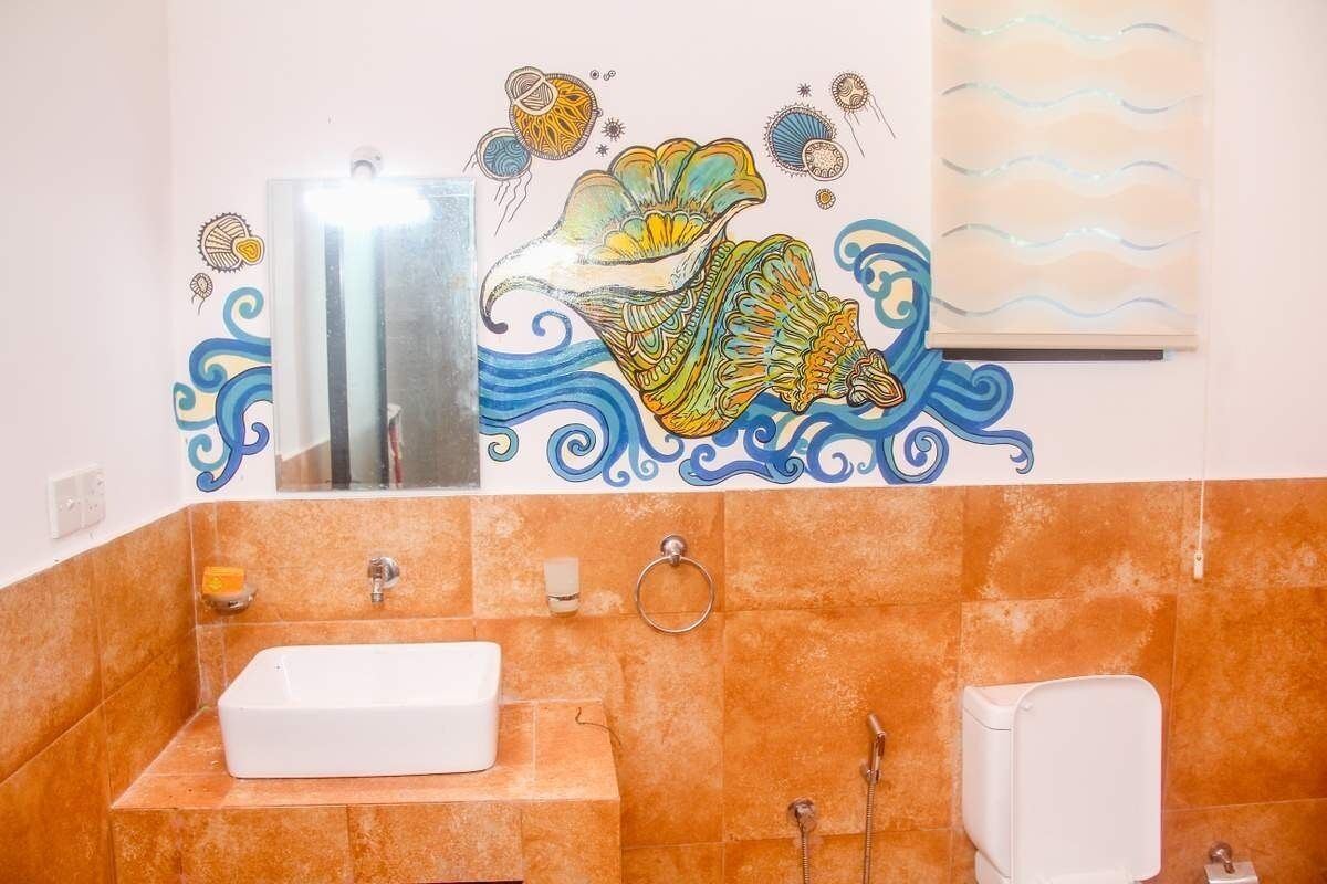 Une salle de bain avec un lavabo blanc, un miroir et une douche.