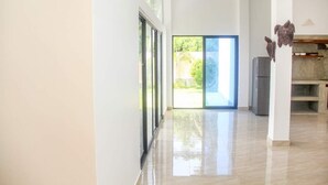 Una cocina moderna con una isla grande, un refrigerador y una zona de comedor con un banco.