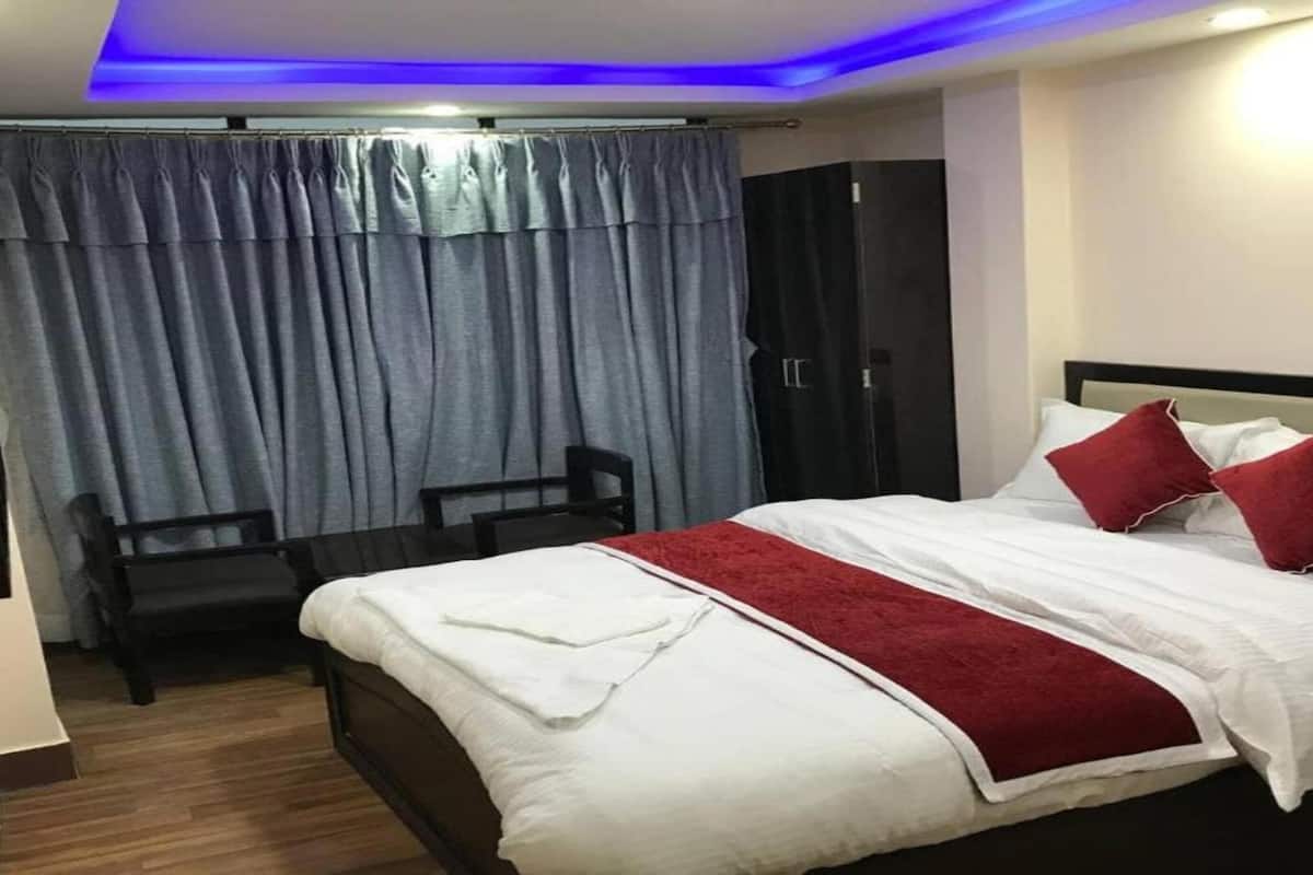 Quarto de hotel com uma cama, uma escrivaninha e uma cadeira.