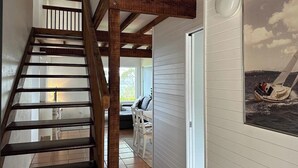 Eine Holztreppe führt zu einem Raum mit Meerblick.
