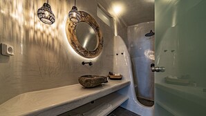 Une salle de bain moderne avec un meuble-lavabo en marbre, un grand miroir et une baignoire sur pieds.