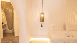 Une chambre moderne avec un grand lit, un luminaire suspendu et un espace douche.