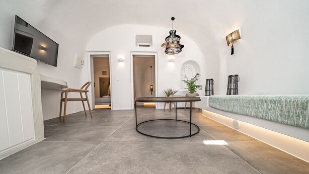 Un intérieur moderne comprenant un coin repas, un téléviseur fixé au mur et un canapé placé contre le mur.