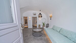 Un salon moderne avec une table basse ronde, un canapé et une porte donnant sur une autre pièce.