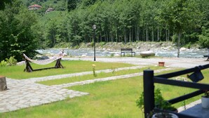 A riverside view with a hammock, a bench, and a lamp post. - Vices Konagi (Findikli)