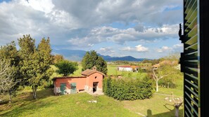 A rural landscape with a small red building surrounded by trees and grass. - Eco House San Michele (Latina)